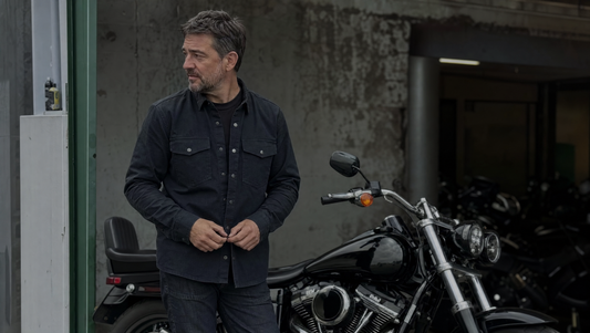 Motorcycle rider in CE-rated casual protective gear beside a cruiser