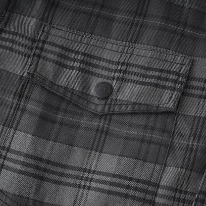 Close-up of a dark gray and black plaid fabric with a buttoned chest pocket.