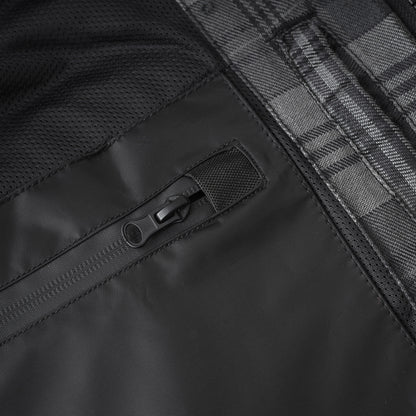 Close-up detail of a black waterproof jacket showing a black zipper pocket, black mesh fabric, and a gray and black plaid pattern.